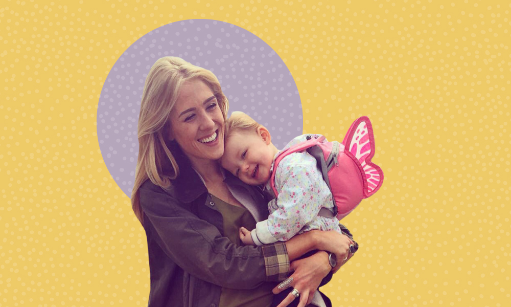 A photo of Elle holding her daughter, both with smiles on their faces. The photo is set against a plain yellow backdrop with a patterned, purple circle behind Elle and her daughter's head.