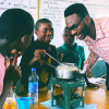 A photo of Henry Anumudu and his students conducting an experiment in the classroom.