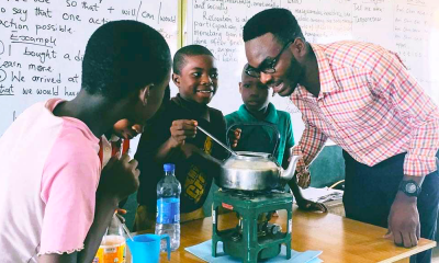 A photo of Henry Anumudu and his students conducting an experiment in the classroom.
