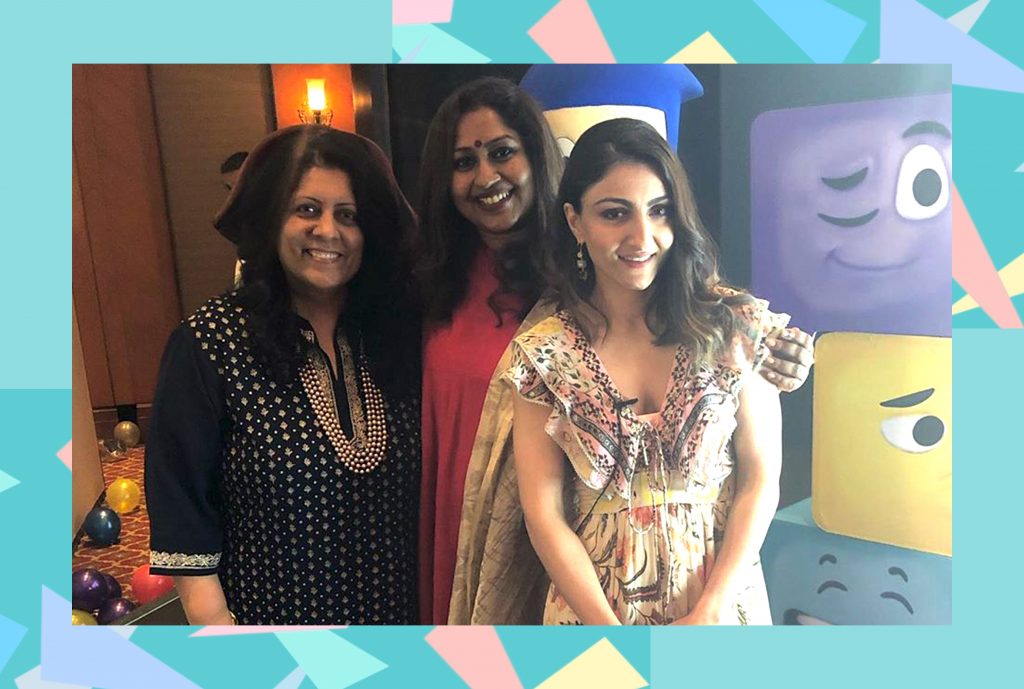 Three Indian Woman, wearing black, read and a patterned dress pose for a photo at a GurgaonMoms meet-up. The lady in the patterned dress is Bollywood actor Soha Ali Khan